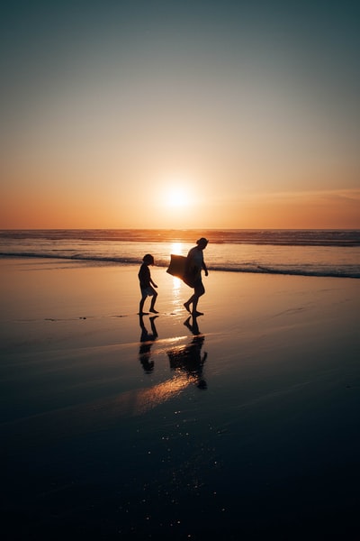 日落时分，两个男人在沙滩上散步